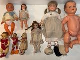 a lot of dolls that are sitting on a shelf