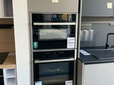 a kitchen with a stove, oven, sink, and cabinets