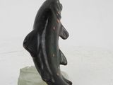 a statue of a dolphin on a rock on a white surface