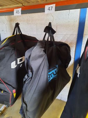 trois sacs de voyage suspendus à un porte-bagages dans un garage