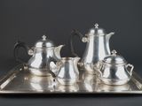 a silver tray with a silver tea set on it
