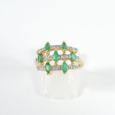 un gros plan d'une bague sertie d'un diamant vert et blanc sur une surface blanche