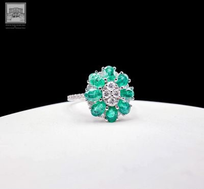 une photo d'une bague sertie d'émeraudes et de diamants