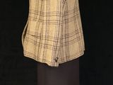 an image of a mannequin wearing a jacket and skirt on a mannequin stand