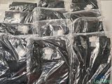 beaucoup de chemises emballées dans des sacs en plastique, posées sur une table