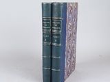 two blue books sitting on top of each other on a white surface