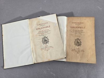 un vieux livre ouvert posé sur une table, à côté d'un livre ouvert