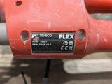 a close up of a red electric tool on a table