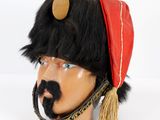 a black and red hat with a mustache on top of a mannequin head