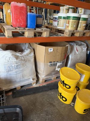 de nombreux seaux de peinture sur les étagères du garage