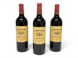 three bottles of red wine sitting next to each other on a white surface