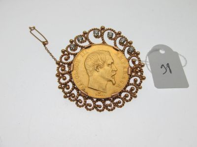 un gros plan d'une pièce d'or à laquelle est attachée une chaîne