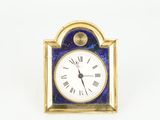 an image of a small clock with roman numerals on the face