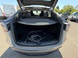 l'arrière d'une voiture dont le coffre est ouvert et dans lequel se trouve un cordon d'alimentation
