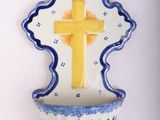 a small blue and white bowl with a yellow cross on it