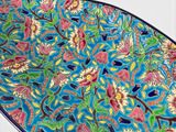 a blue plate with a colorful floral design on it