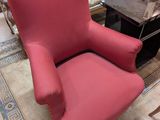 un fauteuil rouge dans un salon avec une table basse