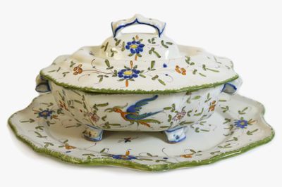 une assiette blanche ornée d'un motif représentant un oiseau bleu et vert