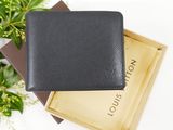 a black wallet sitting on top of a box next to a plant