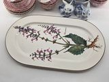 a platter with a design of flowers and leaves on it