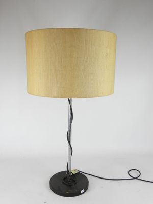 a black table lamp with a beige shade on top of it