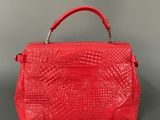 a red leather handbag on a grey background