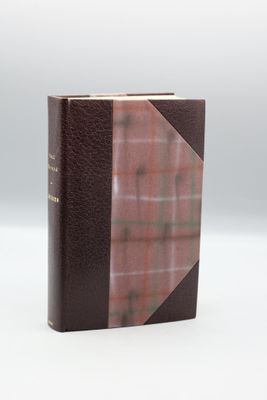 un livre marron à la couverture à carreaux posé sur une table