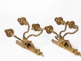 two gold colored candlesticks on a white surface