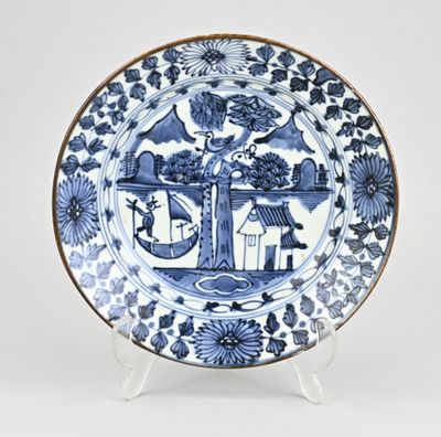 une assiette bleue et blanche sur laquelle est représentée une maison