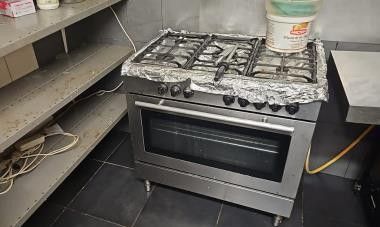 une cuisinière au milieu d'une cuisine dotée de nombreux plans de travail