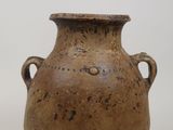 un vase marron muni d'anses, sur un fond blanc