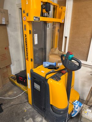 a yellow fork lift truck parked in a garage
