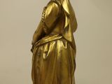 gold statue of a woman with a veil on a wooden base