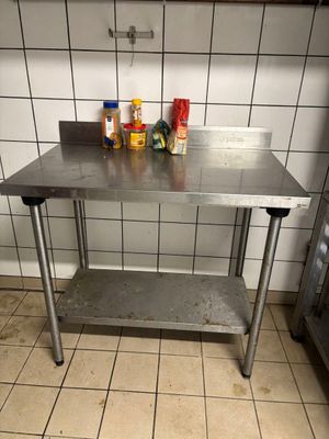 a stainless steel table in a kitchen with spices on top of it