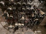 many bottles of wine in a metal rack on the floor