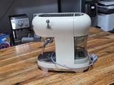 a coffee maker sitting on a wooden table in a kitchen