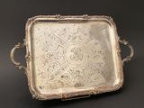 an ornate silver tray with handles and handles on a black background