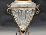 an antique silver and glass covered urn with a bird on top