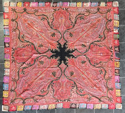 une photo d'un tapis rouge et noir posé sur un sol carrelé