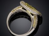 a close up of a ring with a yellow diamond surrounded by white and yellow diamonds