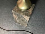 a lamp that is sitting on the floor next to a book shelf