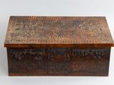 une vieille boîte en bois dont le couvercle est orné de sculptures minutieuses