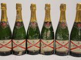 six bottles of champagne lined up in a row on a table