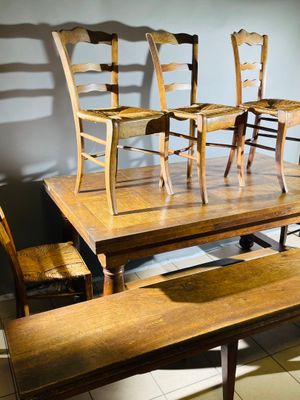 quatre chaises en bois et une table dans une pièce