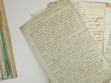some old papers are sitting on top of a table next to a book