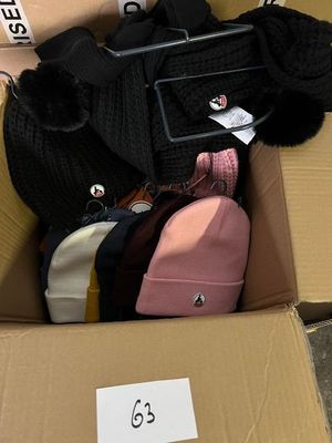 une boîte remplie de chapeaux et un sac sur lequel est accrochée une étiquette de prix