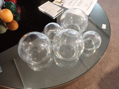 une table en verre sur laquelle sont posés plusieurs verres à vin vides