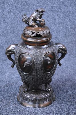 an image of a metal urn with a bird on top of it