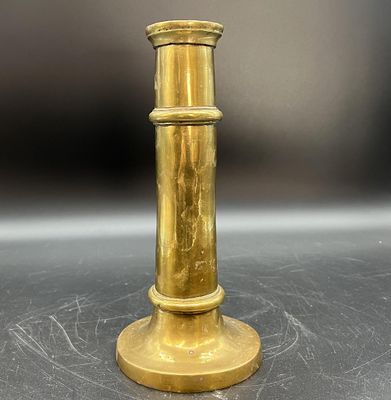 un bougeoir doré posé sur une table, sur fond noir