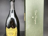 une bouteille de champagne posée sur une table à côté d'un coffret